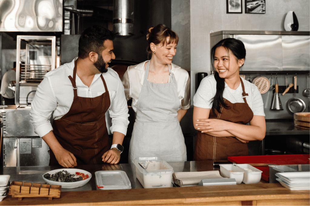 Three restaurant staff members laughing together