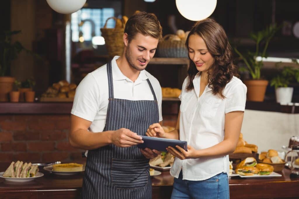 Smiling co-workers using a tablet for online training