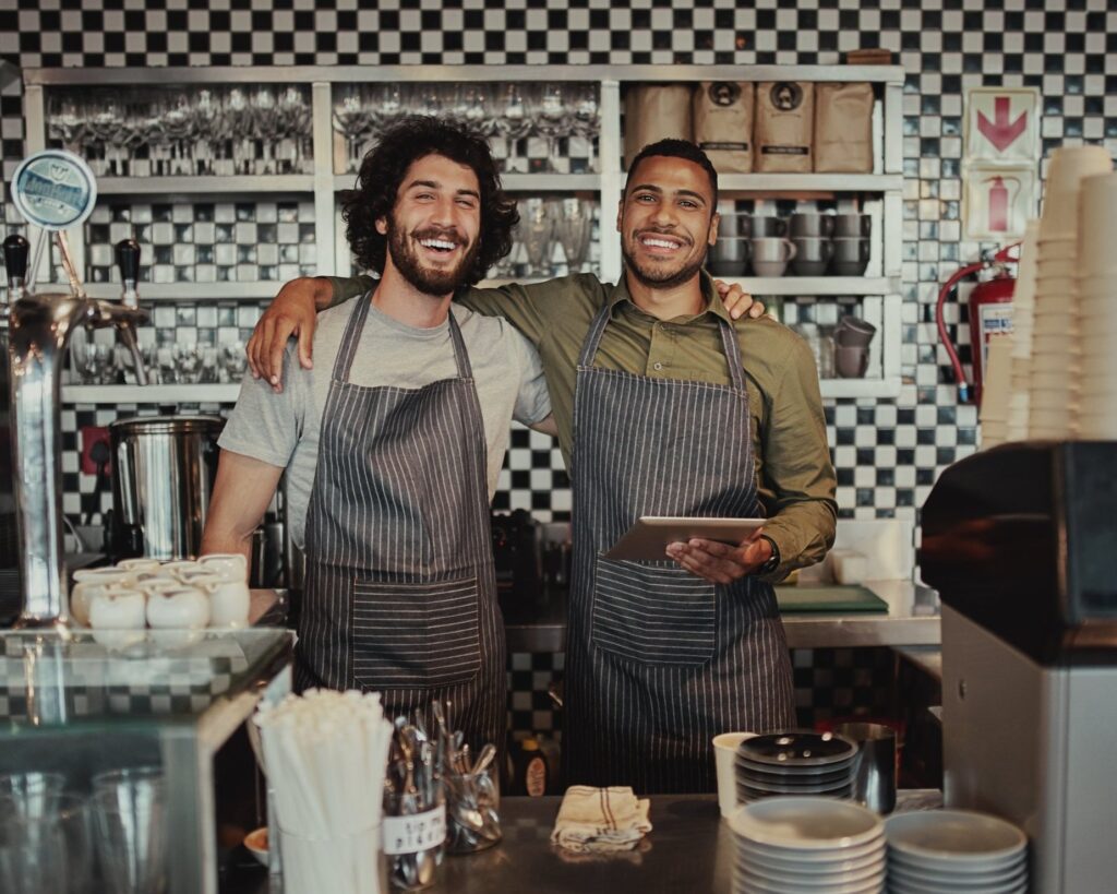 Two team members smiling, one with his arm around the other